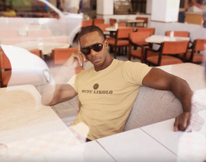 Homme portant un t-shirt beige Mutu Likolo – Collection Résilience, assis dans un café, lunettes de soleil, style décontracté et assuré.

Man wearing a beige Mutu Likolo t-shirt – Resilience Collection, sitting in a café, sunglasses on, relaxed and confident style. 